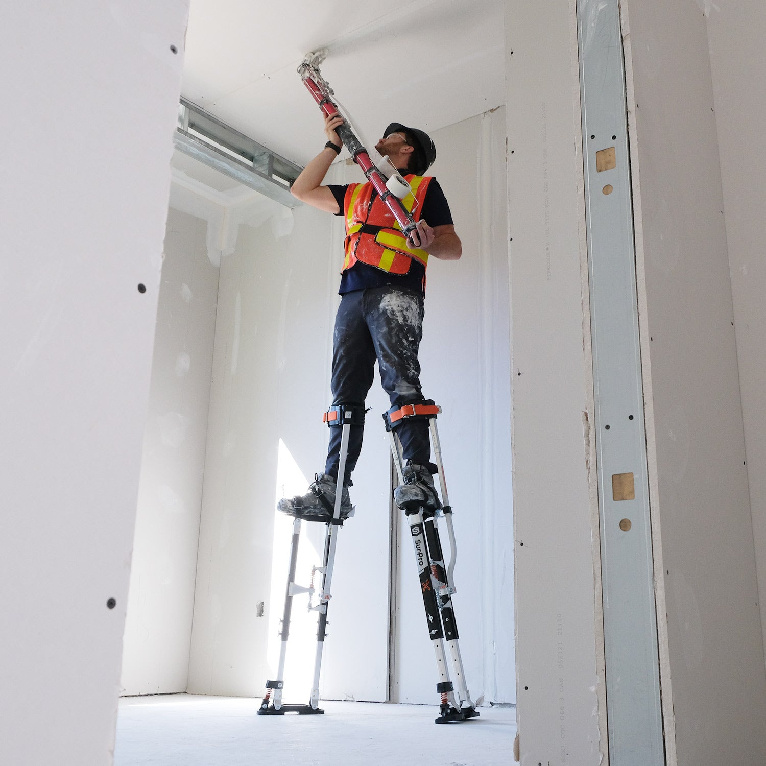 SurPro S2X Magnesium Stilts being used to tape a ceiling with an automatic taper by Brian Kitchin of Drywall Nation